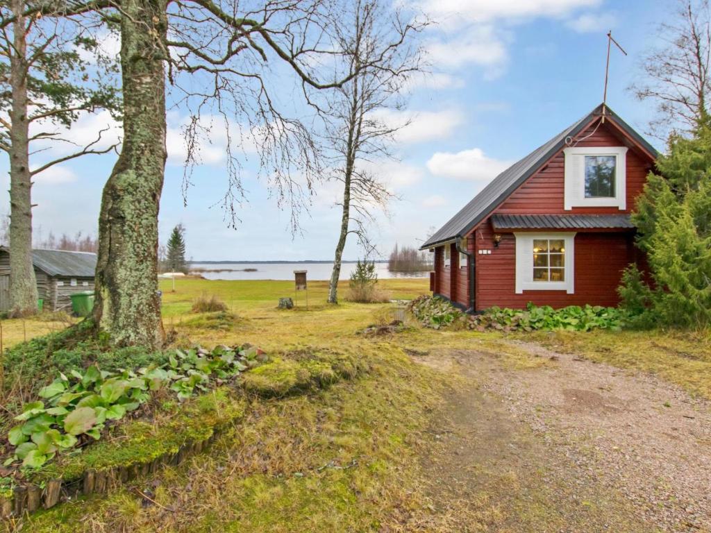 a small red house with a tree in front of it at Holiday Home Missi by Interhome 