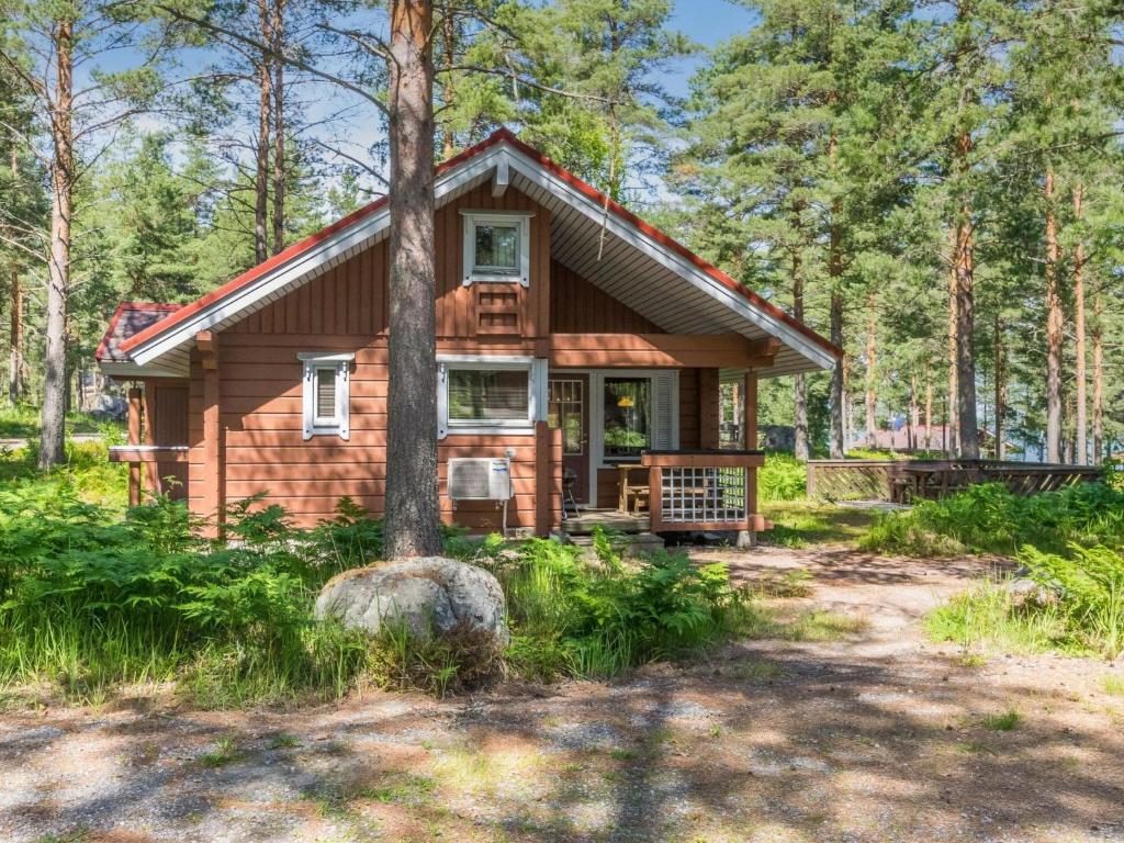 una cabaña de madera en el bosque con un árbol en Holiday Home Karpalo 3 by Interhome en Isnäs