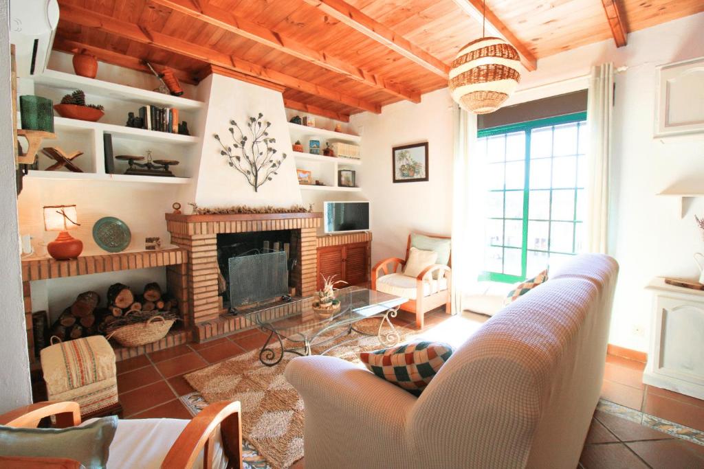 een woonkamer met een bank en een open haard bij El Balcón de Linares by SIERRA VIVA in Linares de la Sierra