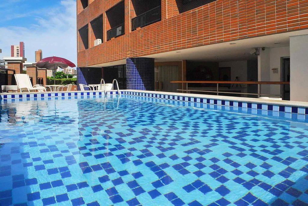 a large swimming pool with blue tiles on a building at Deluxe Rooms By Booking Fortaleza in Fortaleza