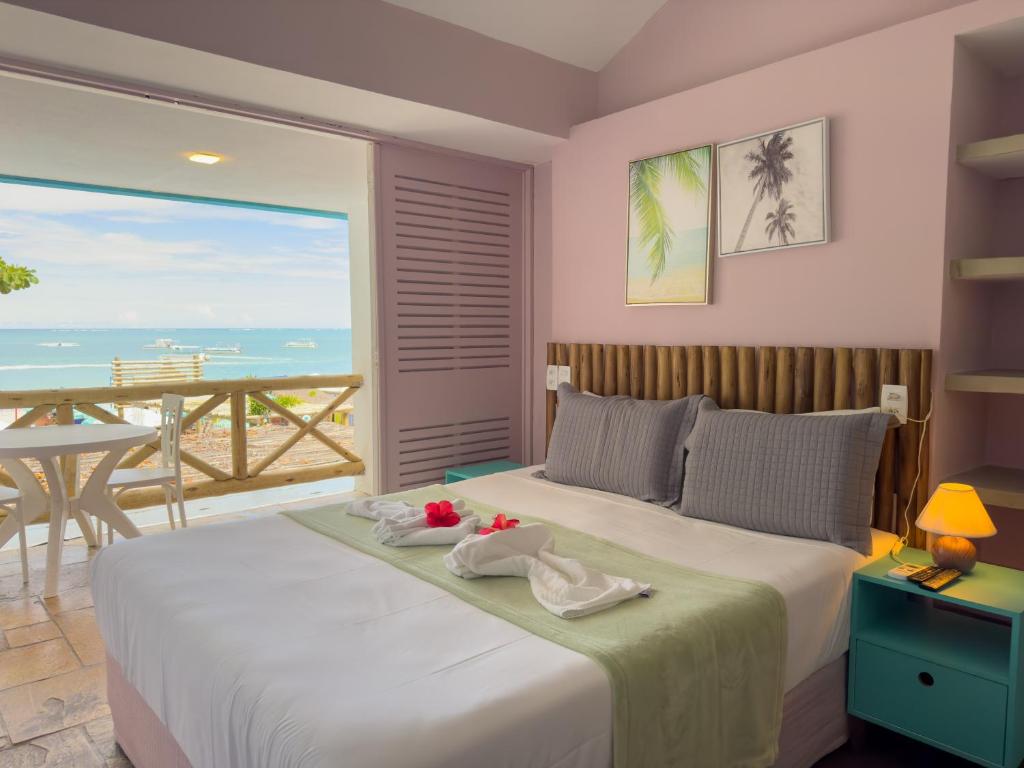 1 dormitorio con 1 cama y vistas al océano en Pousada Meraki Beach, en Maragogi