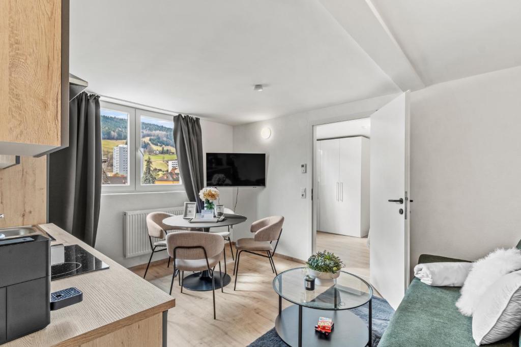 een woonkamer met een bank en een tafel met stoelen bij StayEasy Apartments Leoben P88 #11 in Donawitz