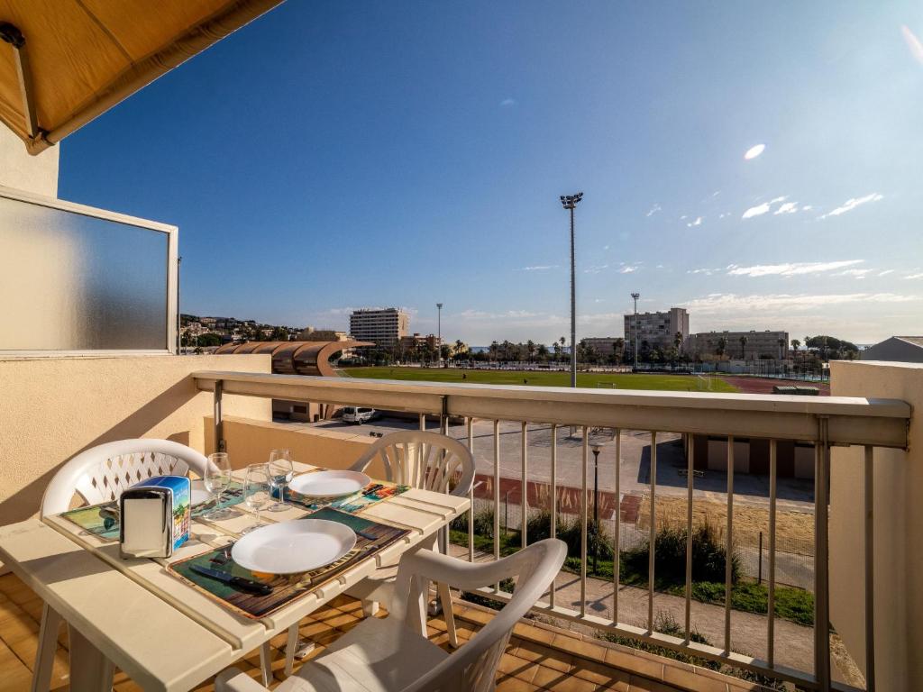 Una mesa y sillas en un balcón con vista. en Studio Ormarine by Interhome, en Le Lavandou