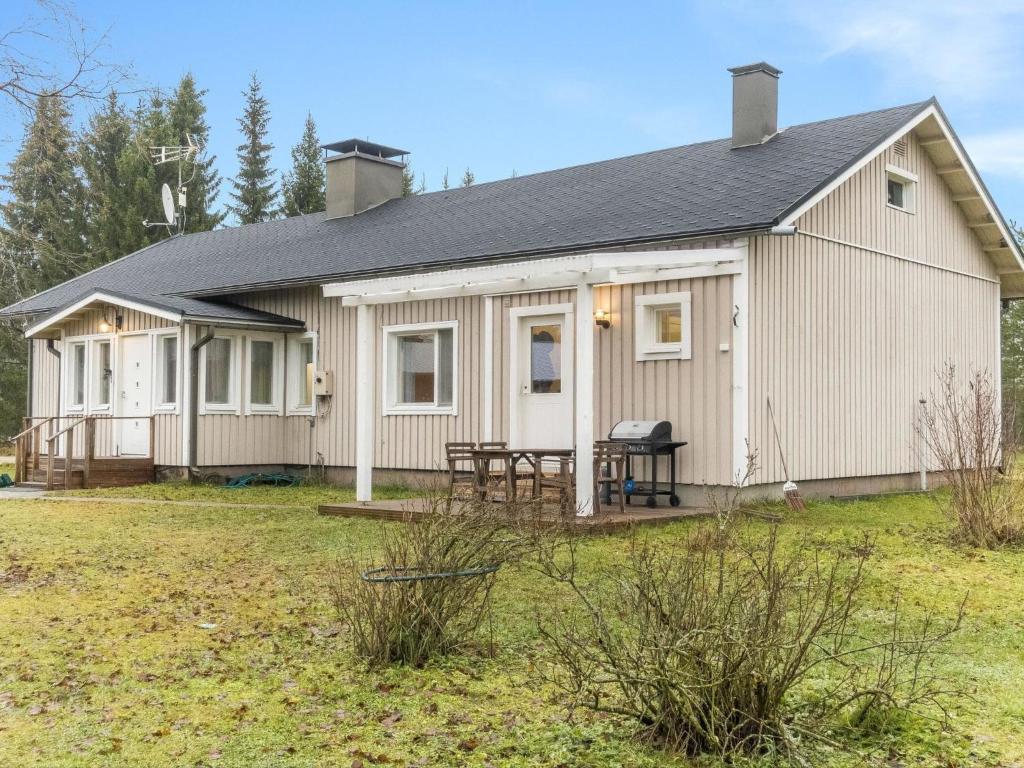 a white house with a picnic table in a yard at Holiday Home Backcountry base by Interhome 