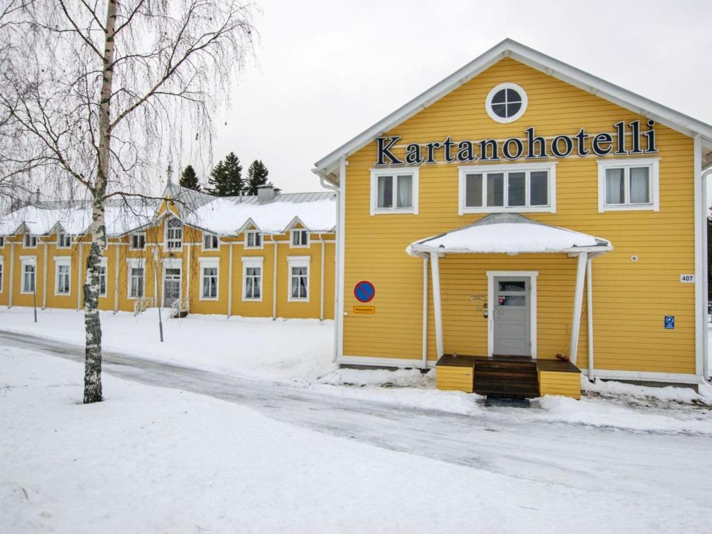a yellow building with a sign on it in the snow at Holiday Home Kartanohuoneisto pekka by Interhome in Runni