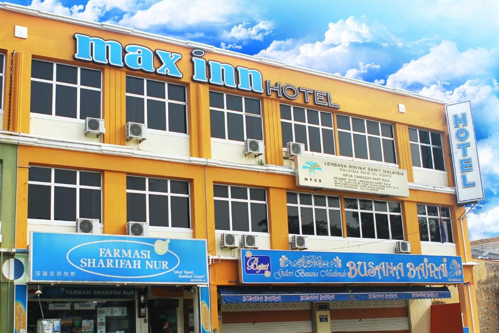 een groot geel gebouw met een max inn hotel bij Max Inn Hotel in Parit Raja