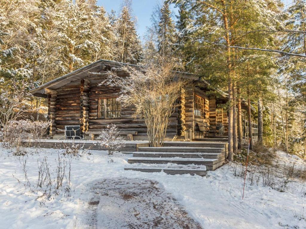 a log cabin in the woods in the snow at Holiday Home Kaasavuoren ranta by Interhome in Röölä