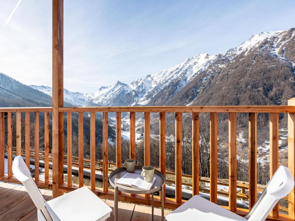 een balkon met stoelen en uitzicht op de bergen bij Apartment I tre Corvi by Interhome in Prali