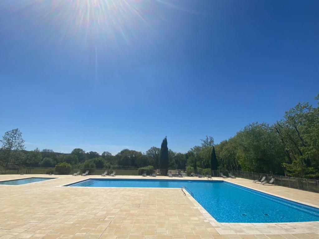a swimming pool with the sun in the sky at Studio Château de Jouarres-1 by Interhome in Azille