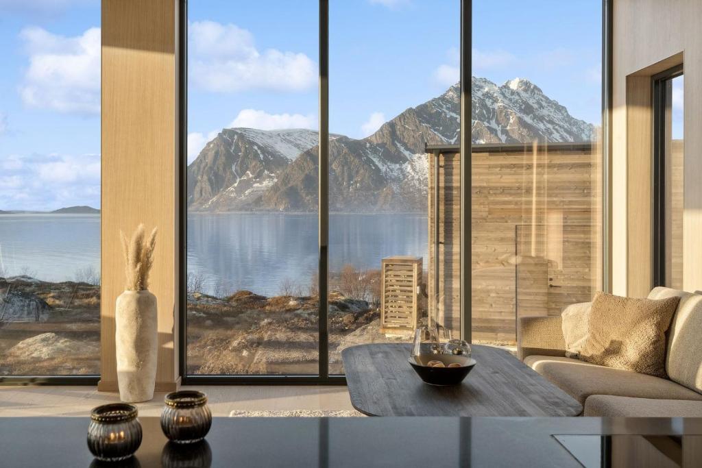 a living room with a view of a mountain at Fjordview Arctic Lodge in Lyngværet