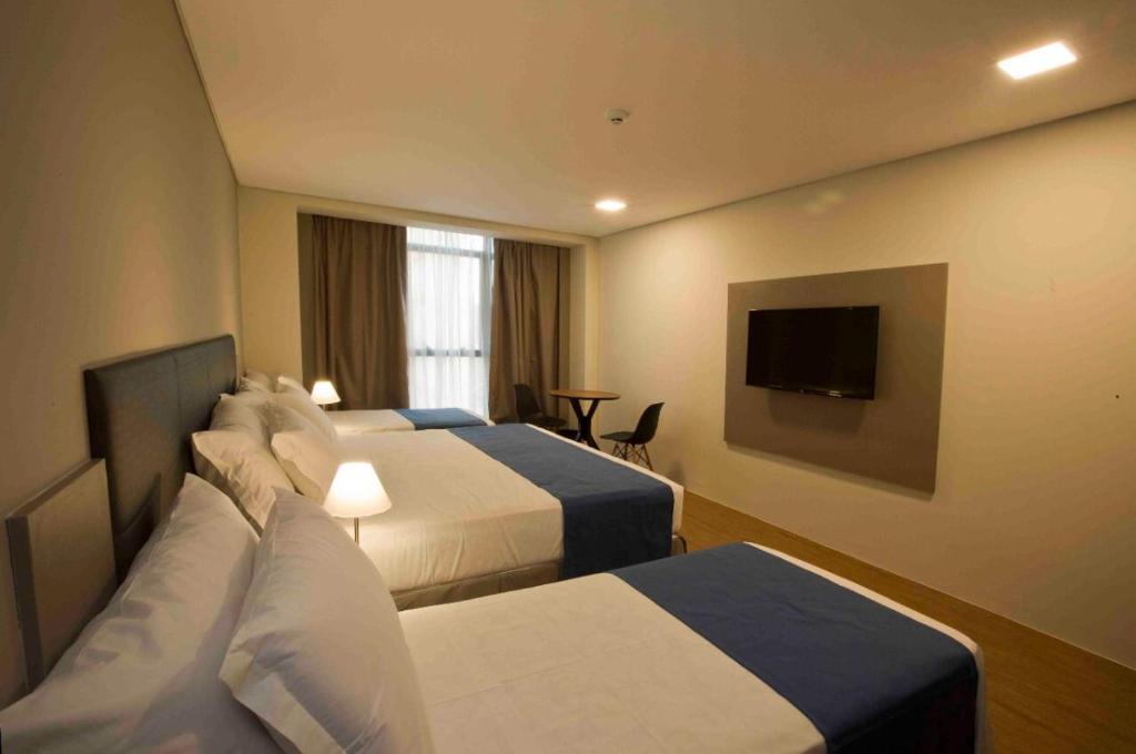 Habitación de hotel con 2 camas y TV de pantalla plana. en Fity Hotel en Recife