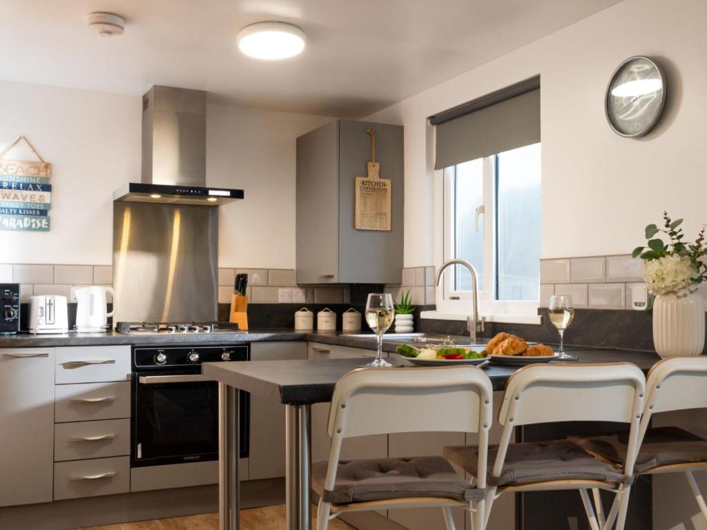 a kitchen with a table with glasses of wine at Chalet Wheal Tor Lodge by Interhome in Helston