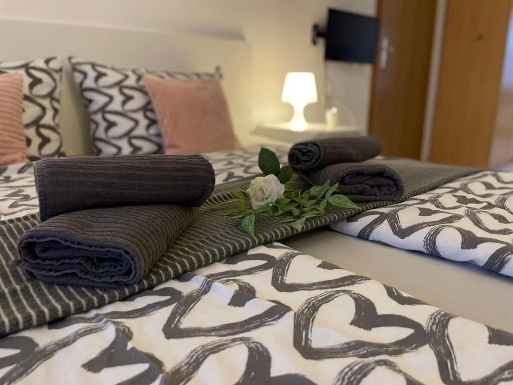 a bed with three towels and a flower on it at Ferienhaus Lenartz in Kliding