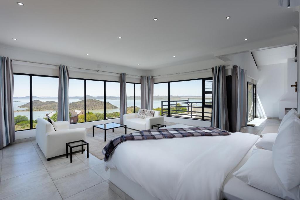 a bedroom with a large white bed and a large window at GARIEPVIEW in Gariep Dam