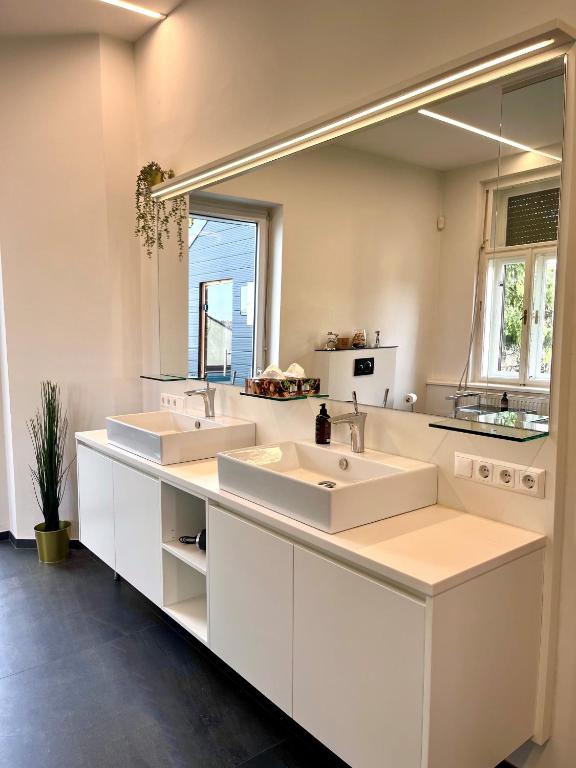 a bathroom with two sinks and a large mirror at LUXUS sApartments in der Kunstvilla &amp; kostenloses parken in Premstätten