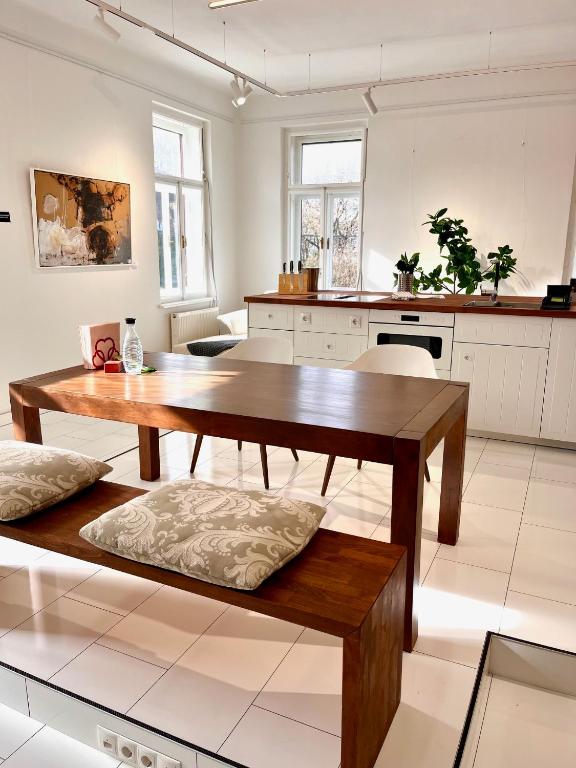 a living room with a wooden table and a kitchen at LUXUS sApartments in der Kunstvilla &amp; kostenloses parken in Premstätten