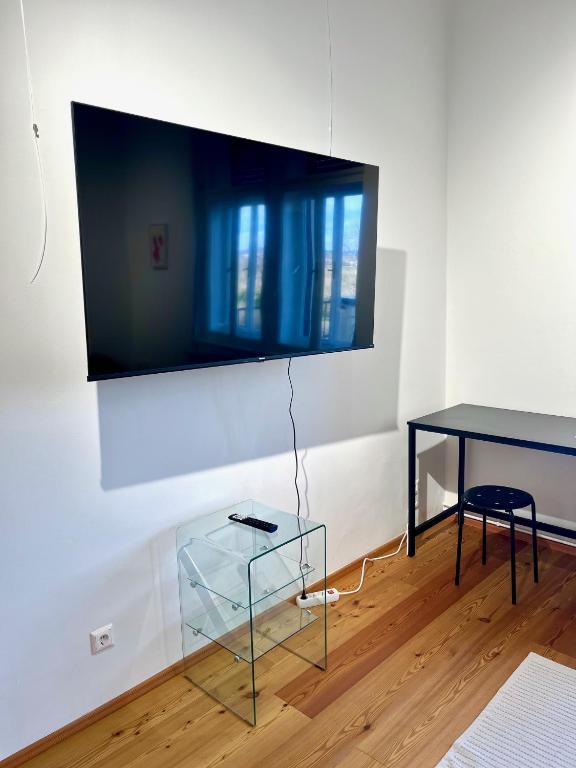 a living room with a glass table and a tv on a wall at LUXUS sApartments in der Kunstvilla &amp; kostenloses parken in Premstätten