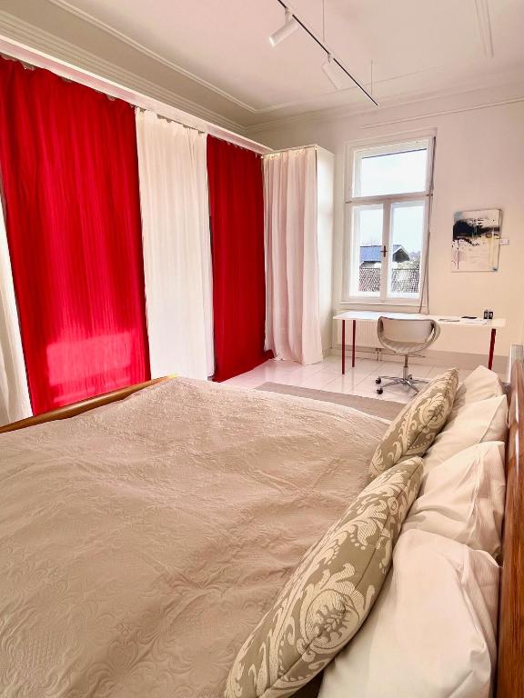 a bedroom with red curtains and a large bed at LUXUS sApartments in der Kunstvilla &amp; kostenloses parken in Premstätten