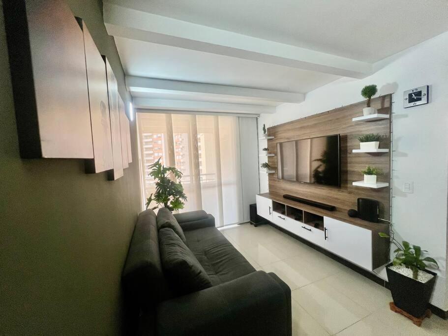 ein Wohnzimmer mit einem Sofa und einem Flachbild-TV in der Unterkunft Acogedor Apto en Bello, cerca del Metro in Bello