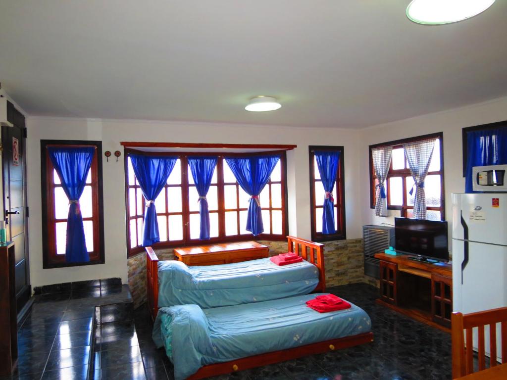 ein Wohnzimmer mit 2 Betten und einem Kühlschrank in der Unterkunft Casa Las Violetas, Ushuaia in Ushuaia