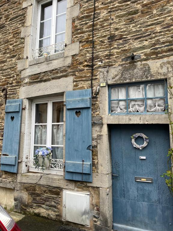 ein Steingebäude mit blauen Türen und Fenstern in der Unterkunft Gîte Pierre et Meuse in Fumay