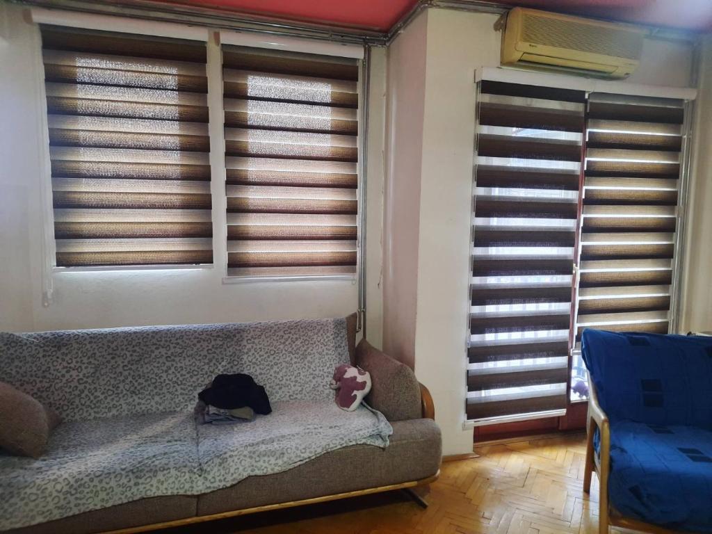 uma sala de estar com um sofá e algumas janelas em Dardani em Pristina