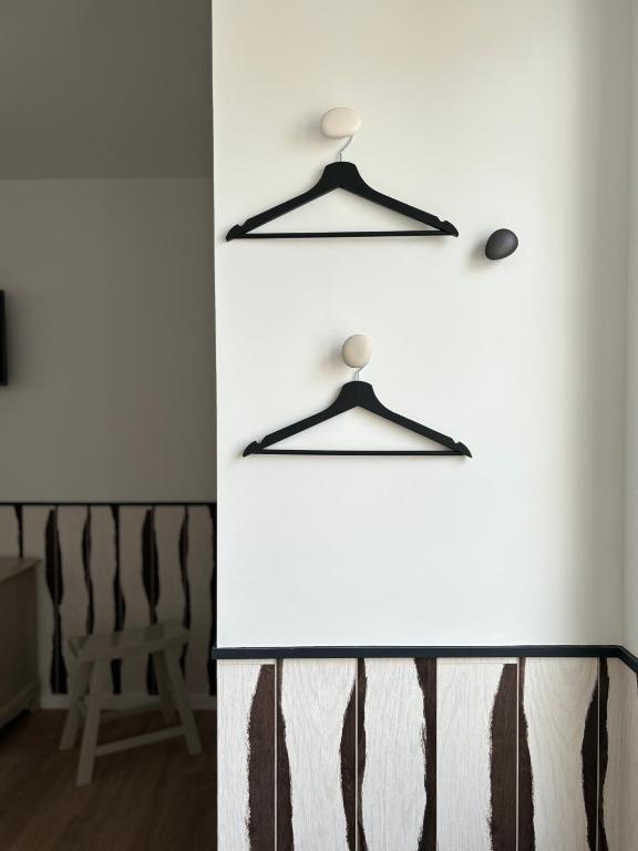 a room with a white wall with two hangers at Hôtel De La Marine in Arromanches-les-Bains