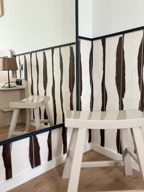 a room with a bench and a wall with stripes at Hôtel De La Marine in Arromanches-les-Bains