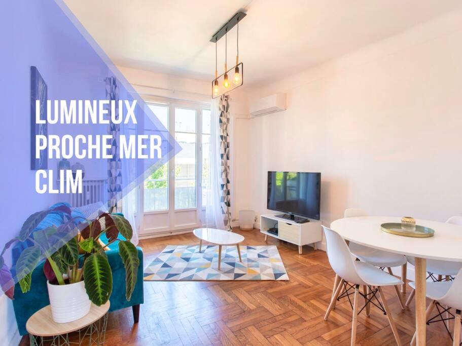 a living room with a table and chairs and a tv at Cassin - Bel appartement T3 proche de la mer in Nice