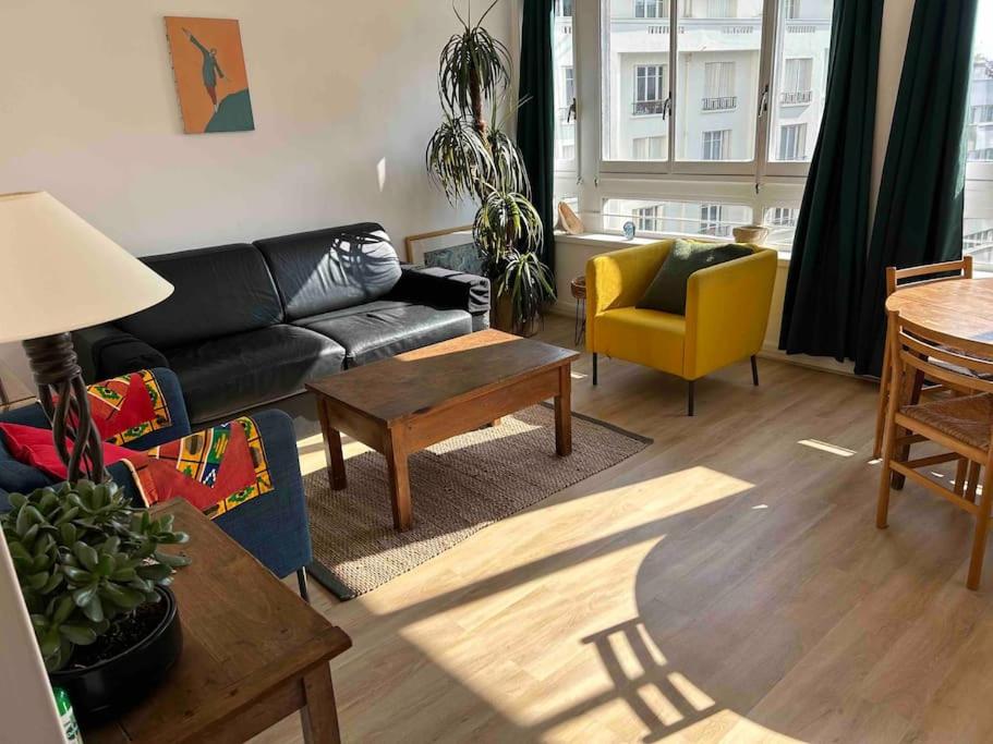 un salon avec un canapé et une table dans l'établissement 2 pièces Lumineux proche du Parc Buttes Chaumonts, à Paris