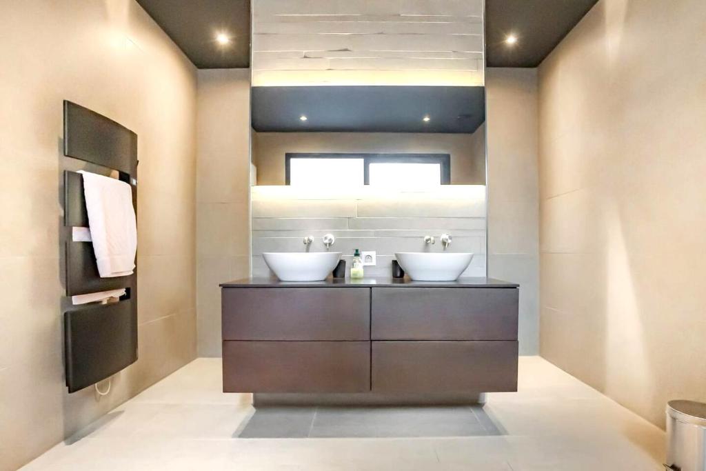 a bathroom with two sinks on a counter with a mirror at Maison de 4 chambres avec piscine privee jacuzzi et terrasse a Noves in Noves
