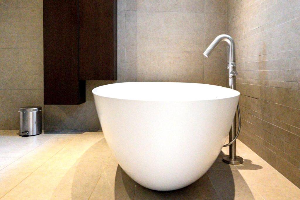 a white bath tub in a bathroom with a faucet at Maison de 4 chambres avec piscine privee jacuzzi et terrasse a Noves in Noves