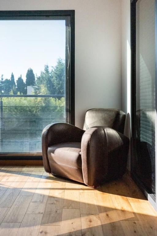a brown leather chair in a room with a large window at Maison de 4 chambres avec piscine privee jacuzzi et terrasse a Noves in Noves