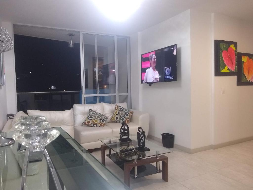 a living room with a white couch and a glass table at APARTAMENTO AMOBLADO SECTOR MARAYA in Pereira