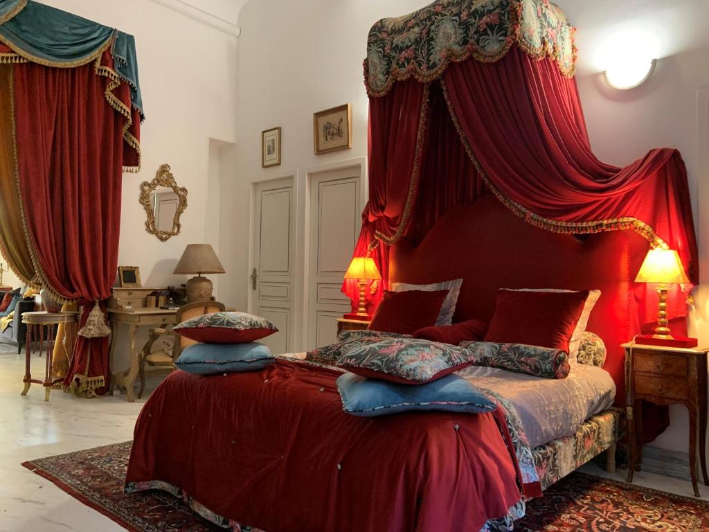 a bedroom with a bed with a red canopy at Petit Trianon - Appartement de Luxe in Aix-en-Provence