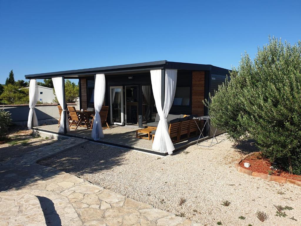 ein Haus mit einem Pavillon davor in der Unterkunft CHARTA mobile home Maya in Pirovac