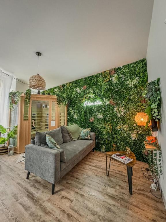 - un salon avec un canapé et un mur vert dans l'établissement Ô Bien-Être, à Morlaix