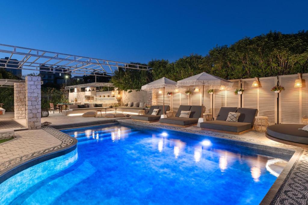 una piscina con sofás y un patio en Vento Imperiale Estate en Rodas