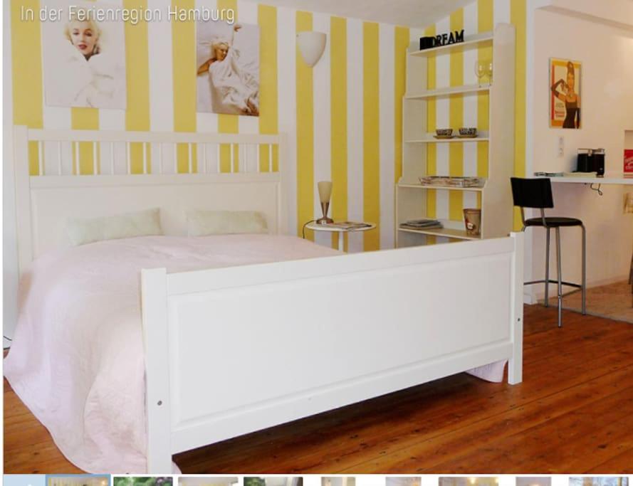 a bedroom with a white bed and yellow stripes at Alster-und Citynahes Apartment in Hamburg