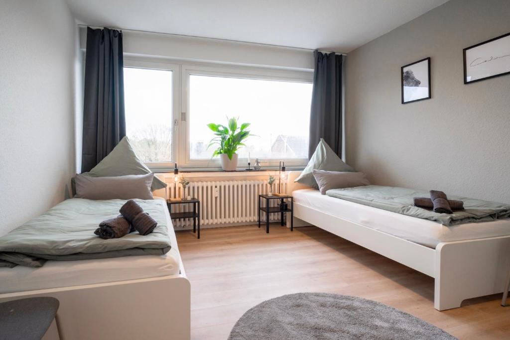 sala de estar con 2 camas y ventana en Juno - #1 Terrassen-Apartment, Netflix, WLAN, en Bottrop