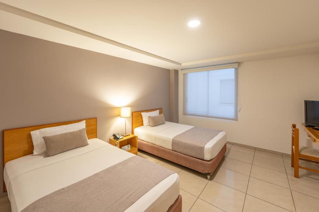 Кровать или кровати в номере Basic Hotel Centenario by Hoteles MS