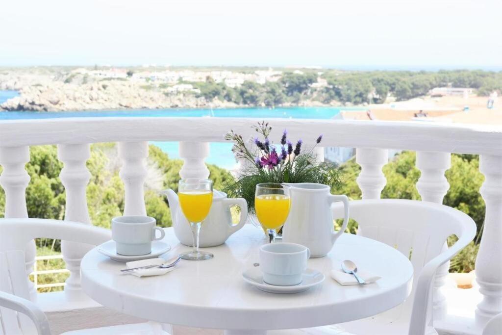 una mesa blanca con dos vasos de zumo de naranja en Apartamento Castellsol 105., en Arenal d'en Castell