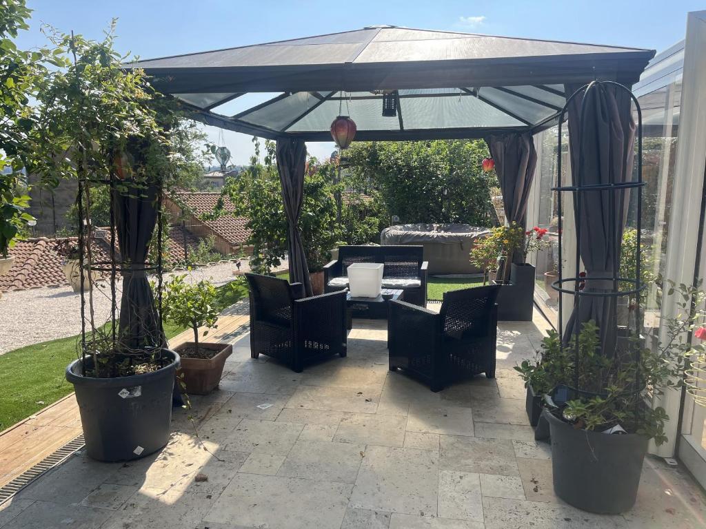 une terrasse avec un parasol bleu, des chaises et des plantes dans l'établissement Maison de charme avec piscine privée à Grasse, à Grasse