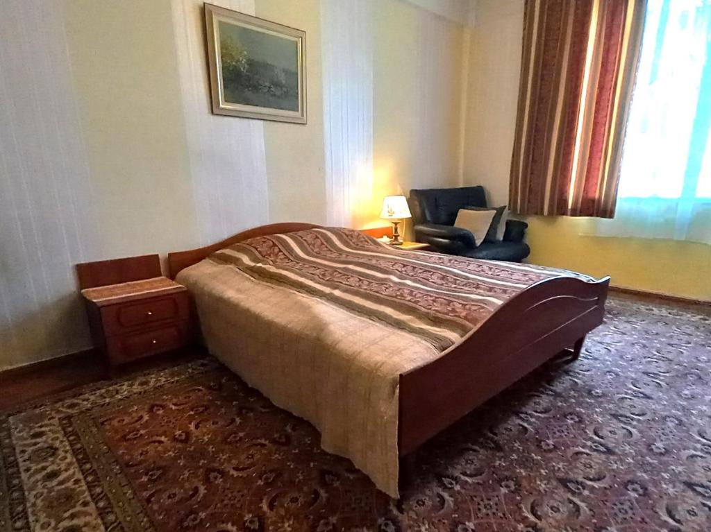 ein Schlafzimmer mit einem Bett und einem Stuhl in einem Zimmer in der Unterkunft Majakovski Guesthouse in Sillamäe