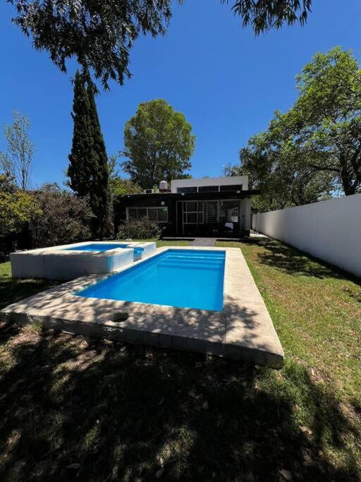 una piscina en el patio trasero de una casa en Hermosa y amplia casa en Roldán en Roldán