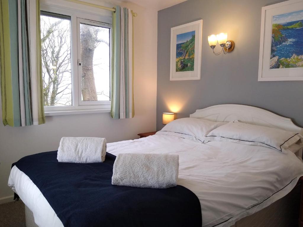 a large white bed in a bedroom with a window at Three bed Holiday Home in Hayle