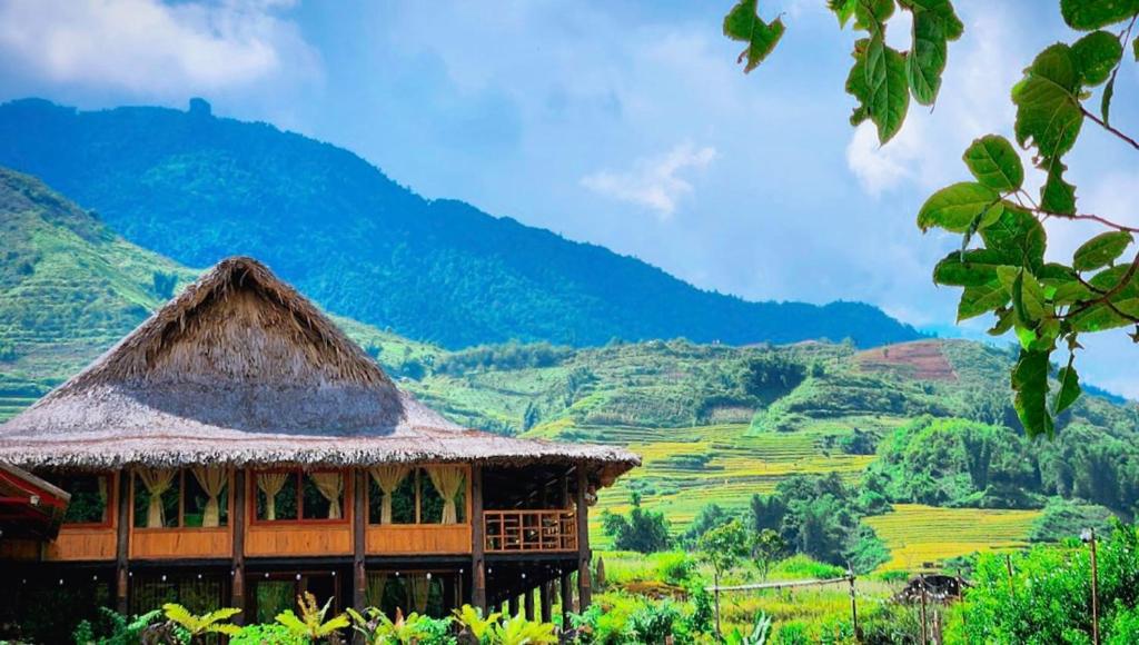 a hut with a view of a valley and mountains at Ngũ Chỉ Sơn Trekking Sapa in Sapa