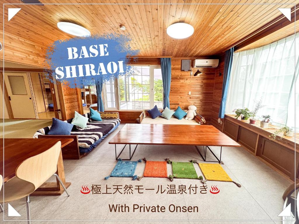 een woonkamer met een bank en een tafel bij Base Shiraoi with Mall Onsen in Shiraoi