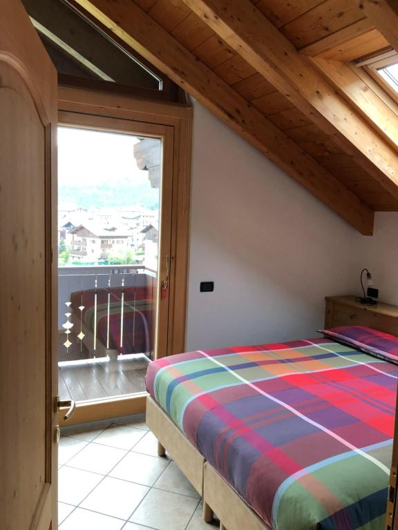 een slaapkamer met een bed en een groot raam bij Casa Vacanze Sablonera in Bormio