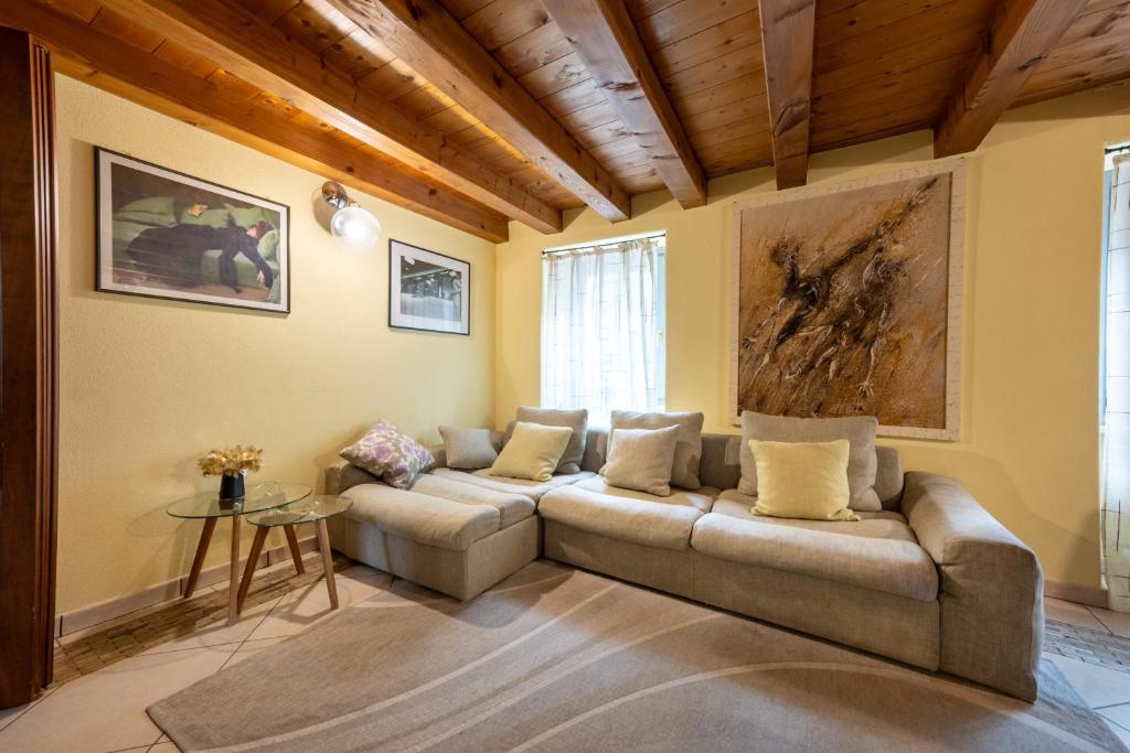 een woonkamer met een bank en een tafel bij Alpine Apartment in Aosta